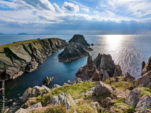 Fotografie, Obraz Irish landscape scene with sunlight shining through the clouds above the cliffs