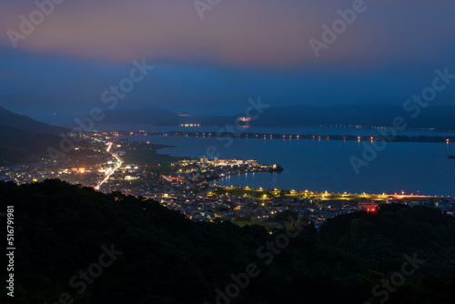 View of Amanohashidate land bridge and city lights in early evening