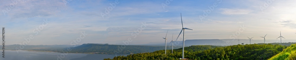 panoramic photo A view that sees a large windmill surrounded by mountains and rivers. panoramic photo A view that sees a large windmill surrounded by mountains and rivers.