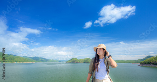Woman carrying a backpack traveling in the mountains,Horizontal view of unrecognizable woman on top of mountain. Travel and holidays concept in summer.