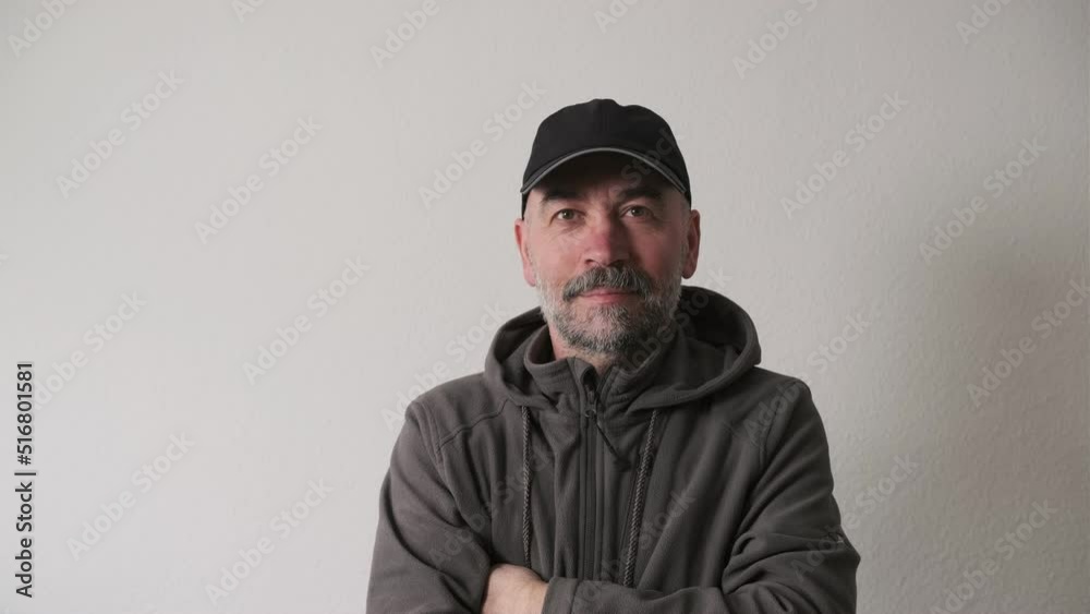 Bearded man in a cap on a white background in the studio looking at the camera and smiles Bearded man in a cap on a white background in the studio looking at the camera and smiles