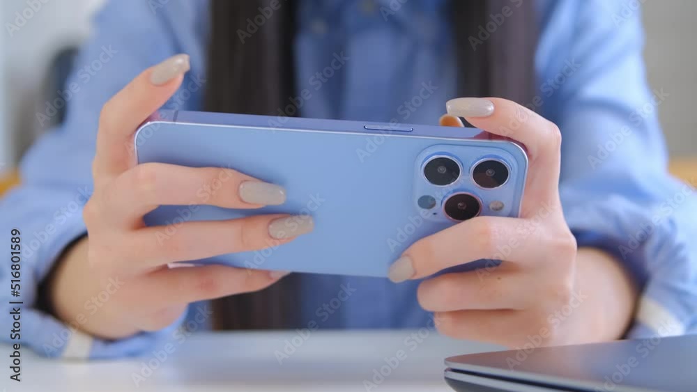 Girl playing mobile games on smartphone. Young female plays game app on modern mobile phone in 4k video