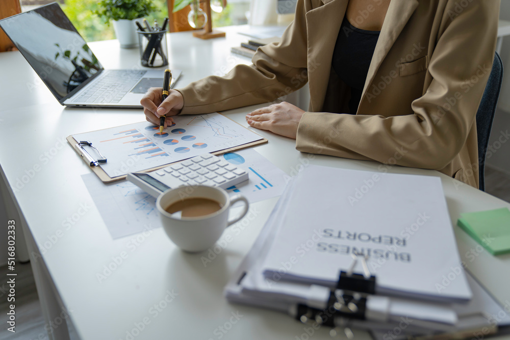 Fototapeta premium A beautiful Asian woman is working on collecting documents and information of the company's financial performance for the meeting. Account Analysis and Audit