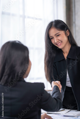 Asian business woman handshake collaborates with partners to increase their business investment network for Plans to improve quality next month in their office. agreement concept.