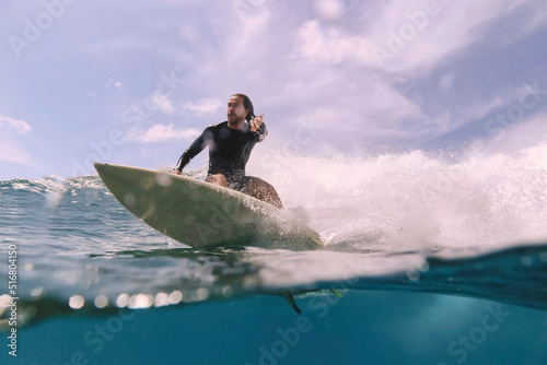 Male surfer on a wave at sunny day photo