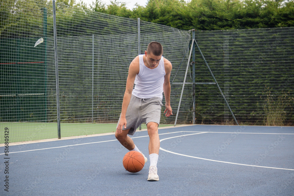 Obraz premium A Nineteen Year Old Teenage Boy Playing Basketball
