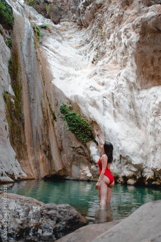 woman in red swimsuit Dimosari waterfall at Lefkada island Greece