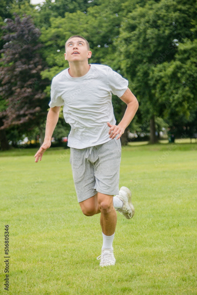 A Nineteen Year Old Teenage Boy Playing Football in A Public Park A Nineteen Year Old Teenage Boy Playing Football in A Public Park