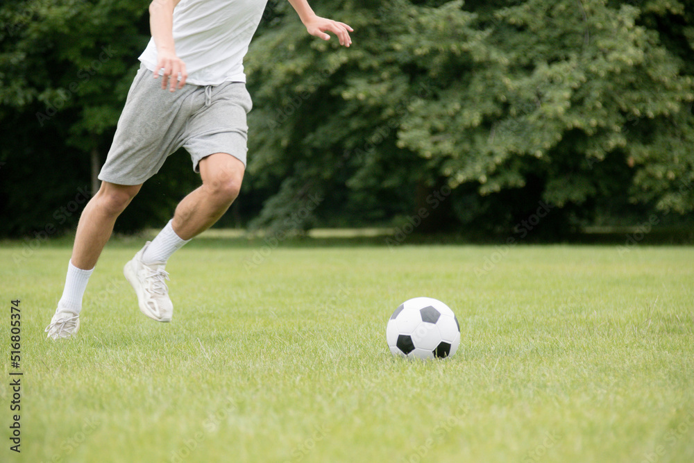 A Nineteen Year Old Teenage Boy Playing Football in A Public Park A Nineteen Year Old Teenage Boy Playing Football in A Public Park