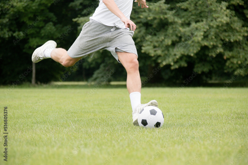 A Nineteen Year Old Teenage Boy Playing Football in A Public Park A Nineteen Year Old Teenage Boy Playing Football in A Public Park