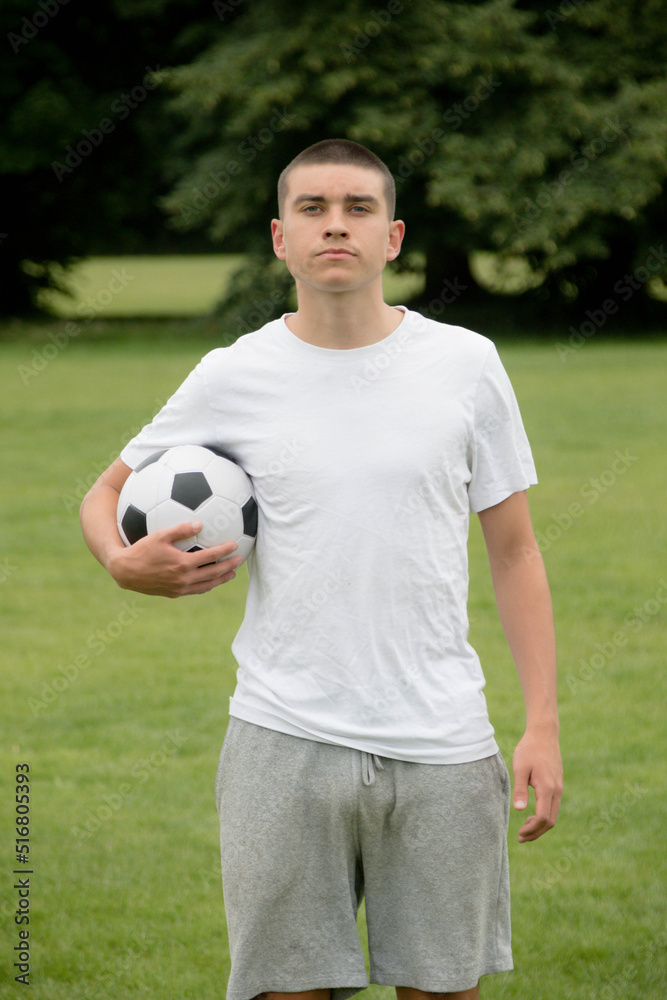 A Nineteen Year Old Teenage Boy Playing Football in A Public Park