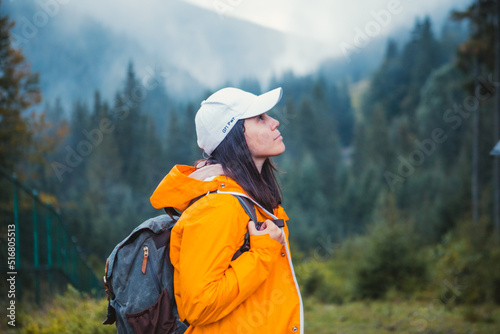 woman in yellow raincoat hiker in autumn mountains