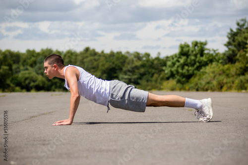 A Nineteen Year Old Teenage Boy Doing Push Ups A Public Park