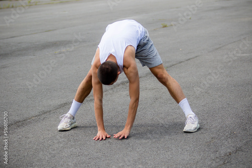 A Nineteen Year Old Teenage Boy Stretching In A Public Park