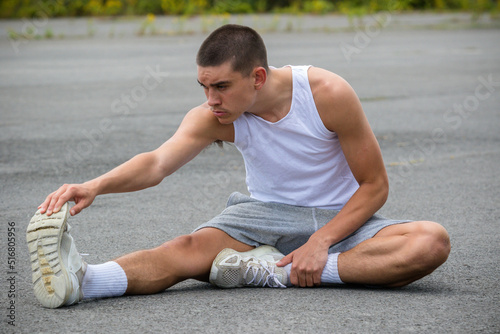 A Nineteen Year Old Teenage Boy Stretching In A Public Park