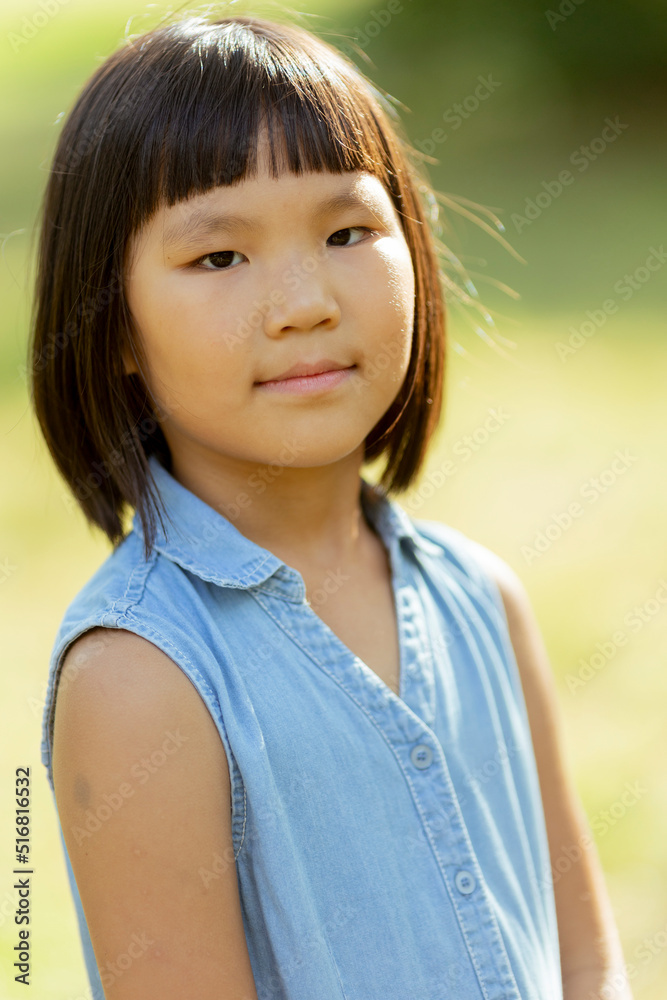 Little Korean girl standing in the park Little Korean girl standing in the park