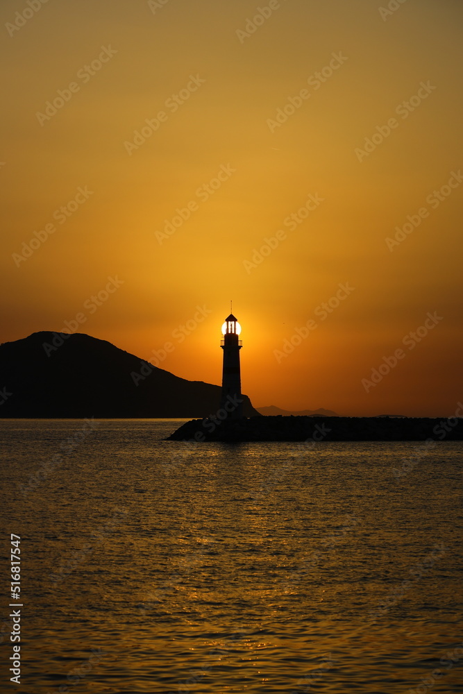 Seascape at sunshine. Lighthouse and sailings on the coast. Seaside town of Turgutreis and spectacular sunshine	