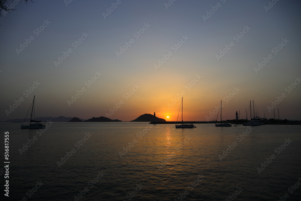 Seascape at sunshine. Lighthouse and sailings on the coast. Seaside town of Turgutreis and spectacular sunshine	