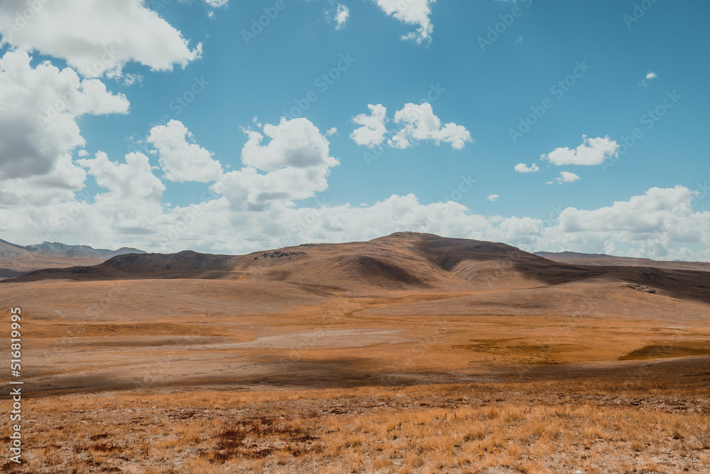 vast mountain hills in empty valley of Deosai National Park in Pakistan on sunny summer day