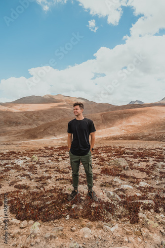 young man standing in rural mountain plains of Deosai National Park on a sunny summer day in northern Pakistan