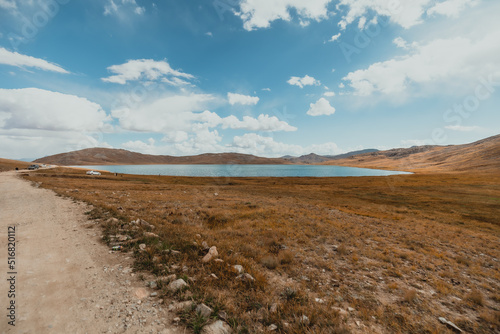 wide landscape view of Shausar lake in Deosai National Park on a sunny summer day in Pakistan © Alexander White