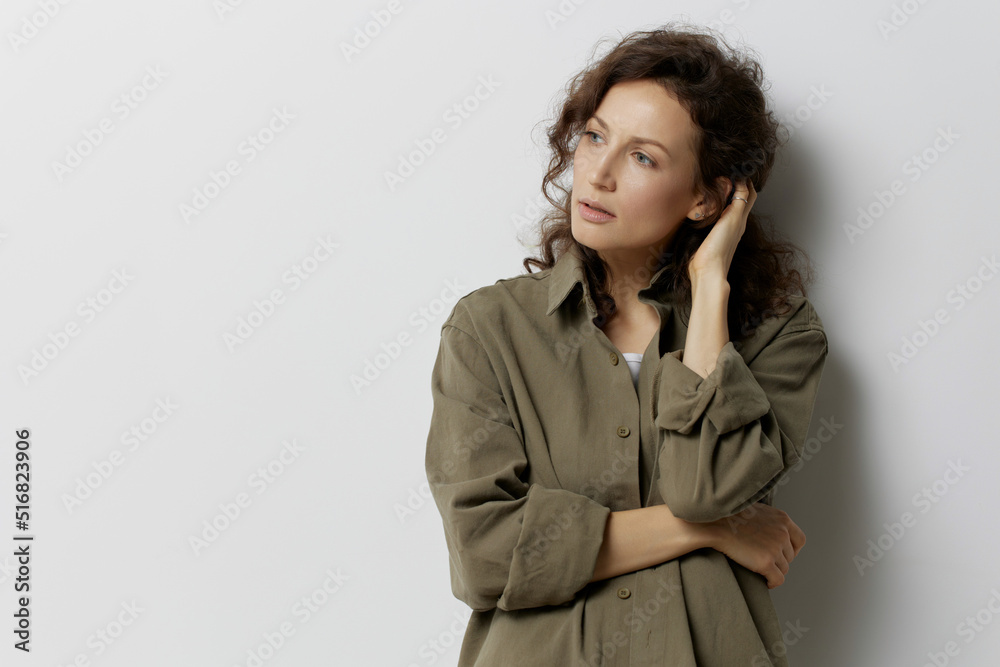 Frustrated pensive curly beautiful woman in casual khaki green shirt thinks about abusive relationships looks aside posing isolated on white background. People Emotions Lifestyle concept. Copy space Frustrated pensive curly beautiful woman in casual khaki green shirt thinks about abusive relationships looks aside posing isolated on white background. People Emotions Lifestyle concept. Copy space