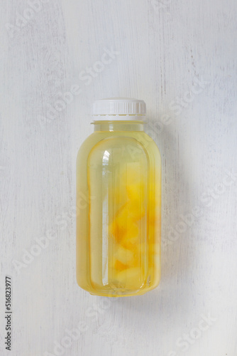 bottle of lemonade on the white background with copy space. top view. bottle with yellow liquid