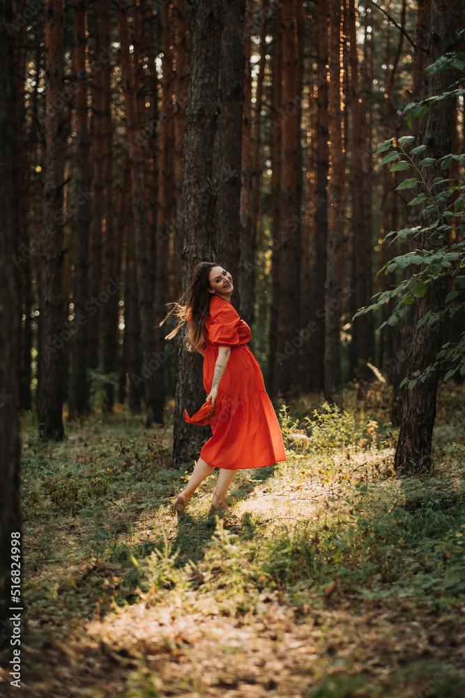 Peace of mind, breathing fresh air. Alone woman in red dress enjoys the tranquility and calm