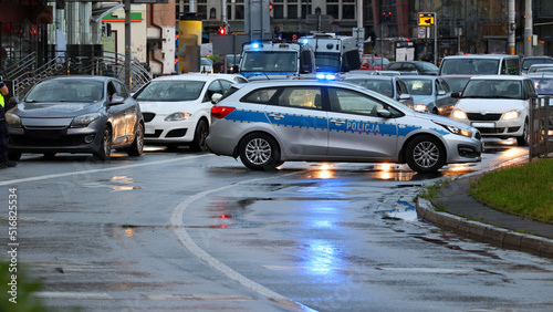 Incydent policji wieczorem w mieście. - Sygnalizator błyskowy niebieski na dachu radiowozu policji polskiej w nocy.