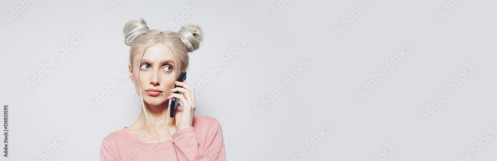 Pretty girl with hair buns, talking on smartphone, on white. Panoramic banner. Pretty girl with hair buns, talking on smartphone, on white. Panoramic banner.