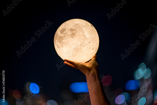 hand grabbing the moon at night