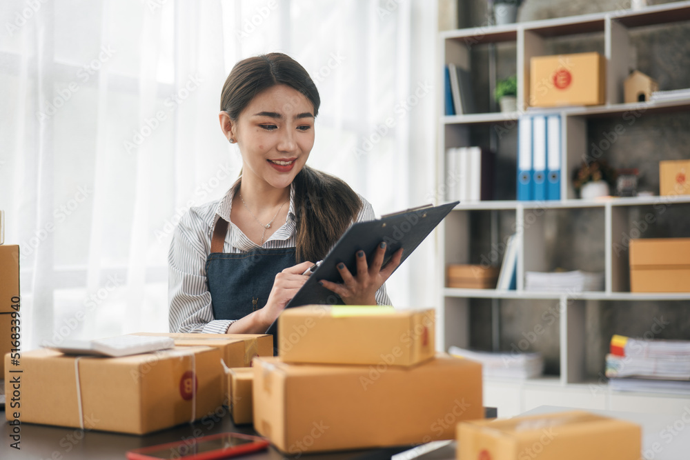 Business woman happy and cheerful for successful for receiving orders from customer via laptop with a lot of parcel boxes for shipping. Business woman happy and cheerful for successful for receiving orders from customer via laptop with a lot of parcel boxes for shipping.