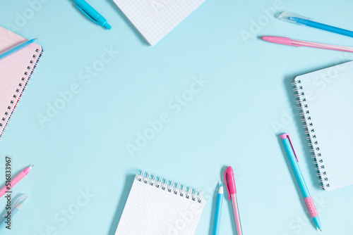 Back to school. Creative minimalist school or office supplies, notebook, pen on blue background. Education concept. Flat lay, top view, copy space