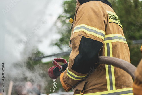 Fotografija Firefighter fights flames, extinguish fire, big house fire catastrophy