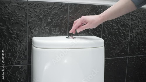 the woman closes the toilet lid and flushes the water. Toilet close-up. photo