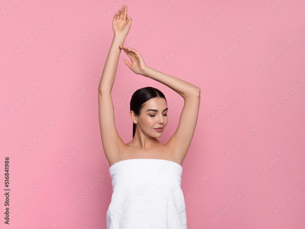 Young woman showing smooth skin after epilation on pink background Young woman showing smooth skin after epilation on pink background