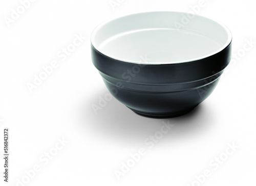 Empty ceramic bowl, black outside, white inside, isolated on white