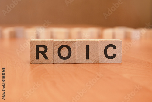 wooden cubes with the inscription - ROIC, brown background