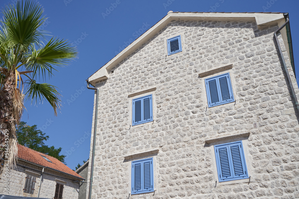 Stone house with blue shutters in a European village