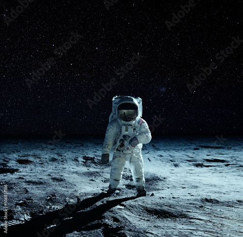 Fototapeta Naklejka Na Ścianę i Meble -  Astronaut at the spacewalk on the moon. National Moon Day. Elements of this image furnished by NASA.