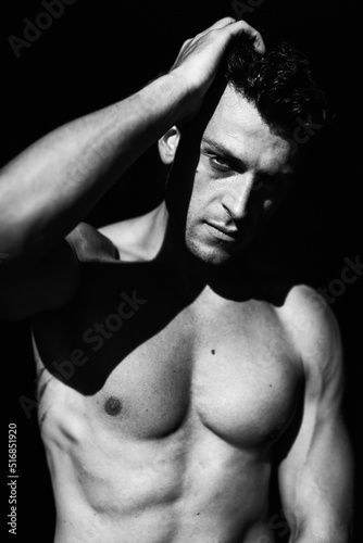 Muscular male model poses in black and white artistic photos