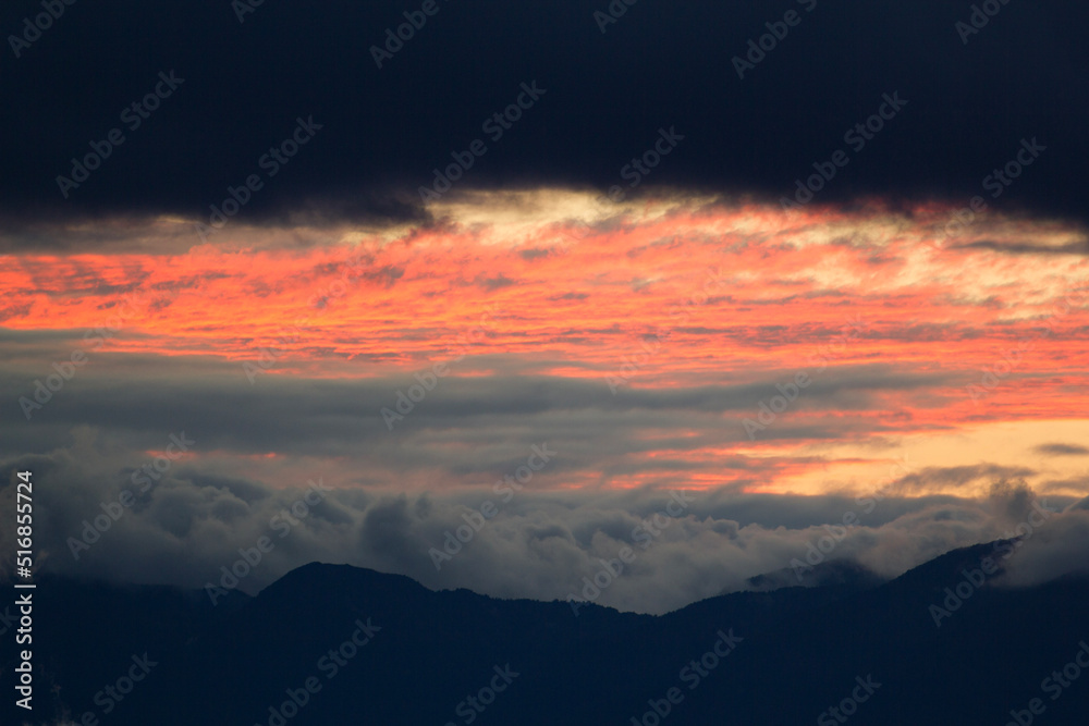close up of a cloudy and fiery sunset over the mountains