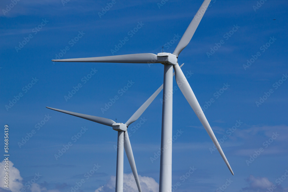 two wind turbines against a blue sky two wind turbines against a blue sky