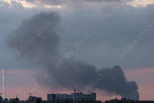 Smoke from a fire after the explosion of a missile in the city. Evening.