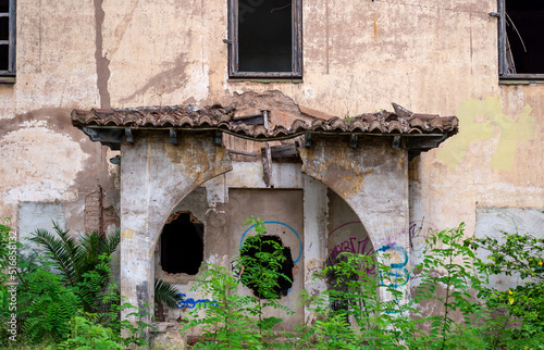 Fototapeta Naklejka Na Ścianę i Meble -  photo of the front entrance of an abandoned building with columns and a broken roof on the porch