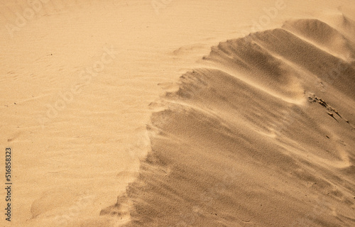 Texture of sandy dunes shinning in the sunlight 