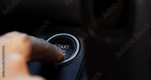 A Caucasian Man hand presses the engine start button in a luxury off road suv in a sunny day under the forest, slow motion video, closeup shot, 4+ resolution, Apple prores file