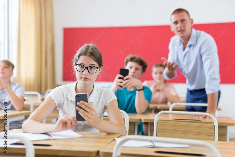 Fototapeta premium Students using smartphones in university class
