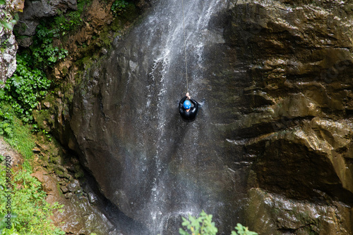 alpinist climbing down a waterfall