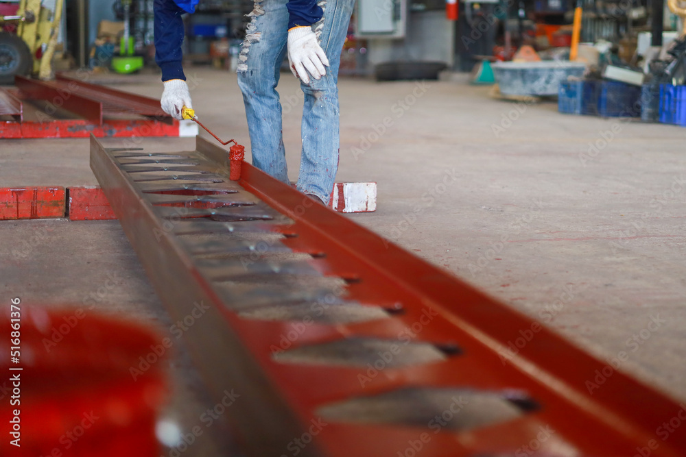 Fototapeta premium Worker painting steel beam in construction site